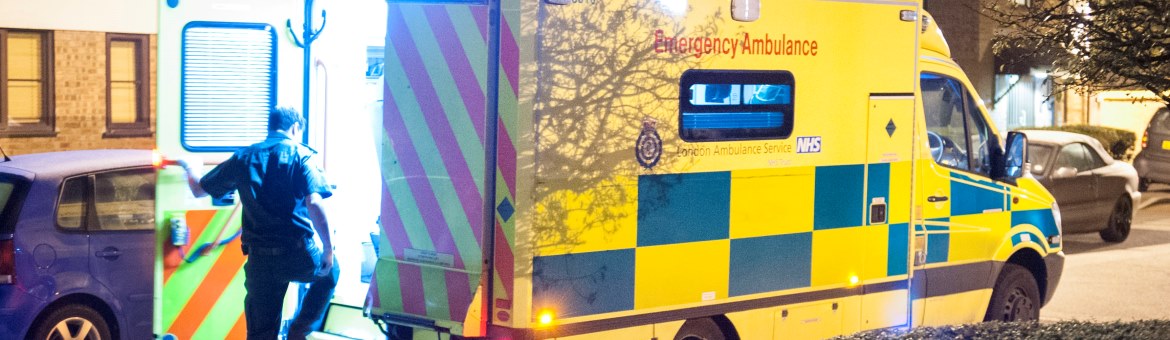 A medic steps into the back of an open ambulance rear door