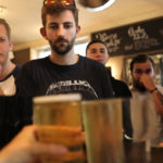 Young people ordering beers in a pub