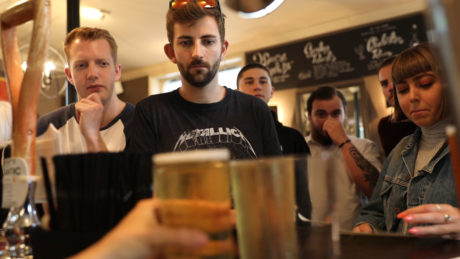 Young people ordering beers in a pub