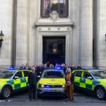 Three new response cars parked in front of the Freemasons building with people stood behind