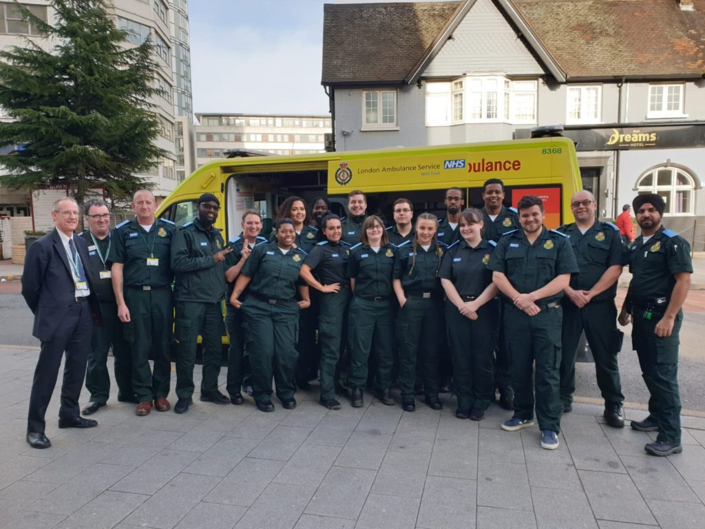 A large group from our Non Emergency Transport Service stood in front on an ambulance