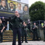 Various LAS staff and two military personnel clapping in front of LAS headquarters