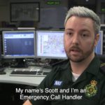 Scott in uniform in front of control room screens