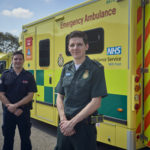 Tom and Jack stood in their uniforms in front of an ambulance.