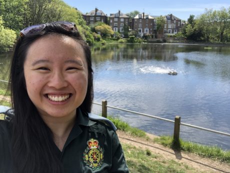 Joyce, in LAS uniform, smiles as she stands in front of lake on a sunny day