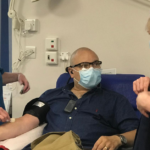 Richard having his arm prepared to donate blood plasma by a nurse