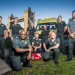 Group of ambulance staff in front of ambulance and Tower Bridge