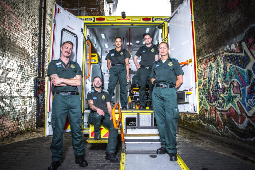 Group of ambulance staff by rear of open ambulance