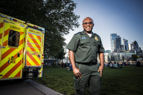 Femi stood next to rear of ambulance