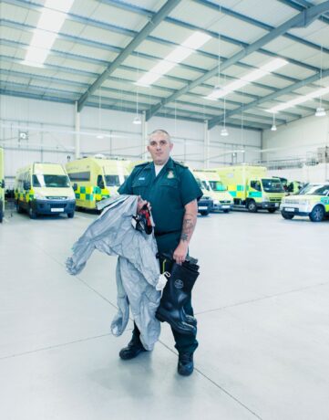 Simon Woodmore with hazardous area clothing with ambulances in background