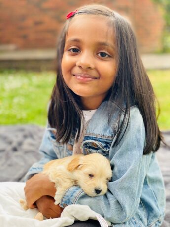 Avaana holding a puppy smiling