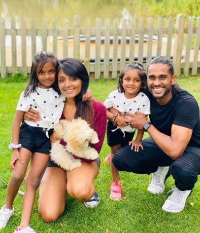 Avaana and her family crouched smiling in a field 