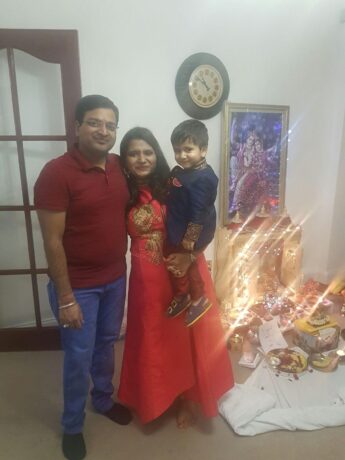 Monia, her husband and son in front of Diwali decorations