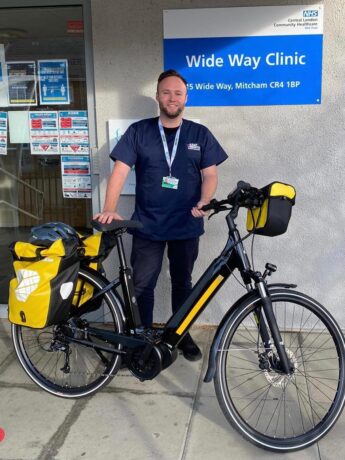 A paramedic stood in front of a clinic with his electric bike