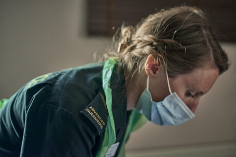 Female medic with face mask on and apron