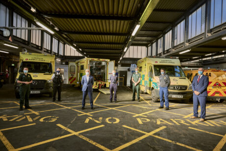 Paramedic, firefighter, Mayor of London, police officer, fleet technician and LAS chief operating officer in front of a row of ambulances