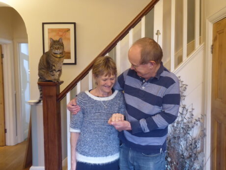 Sally and Brian at home with arms round each other