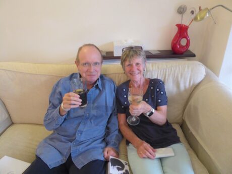 Brian and Sally sat on a sofa raising a glass eacg