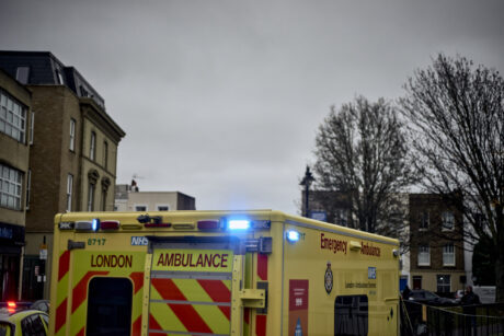 an ambulance with flashing lights on a London street