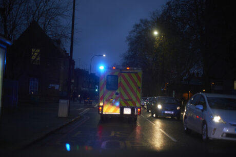 an ambulance with flashing lights on a dark street