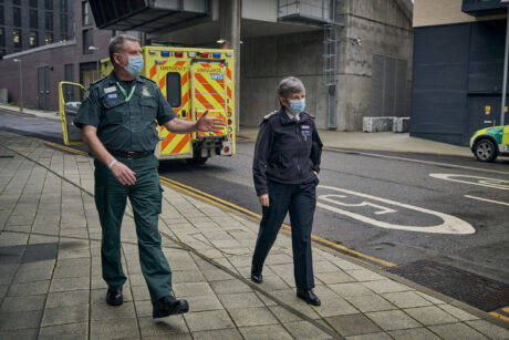 Met Commissioner walking alongside LAS staff member with an ambulance in background