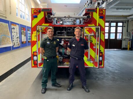 Matt and Dave in their respective Service uniforms stood behind a fire engine