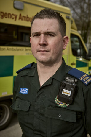 Gary stood in front of an ambulance with his body worn camera attached to his uniform