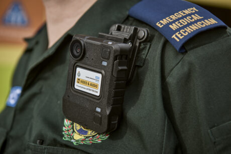 A close up photograph showing a body worn camera attached to ambulance medic uniform