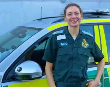 Elisabeth stood in ER green LAS uniform in front of a response car