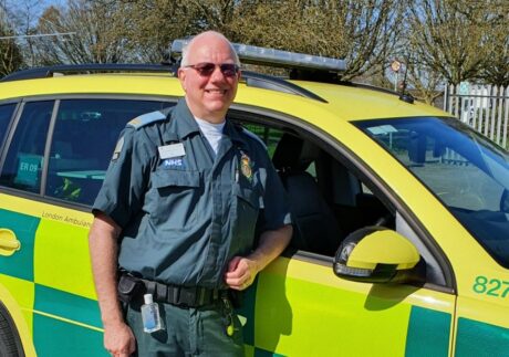 Ian stood in uniform next to an LAS response car