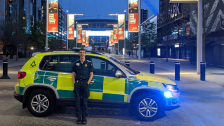 James stood in front of an ambulance car with Wembley Stadium in background