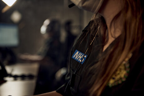 The uniform of a call handler and part of her headset shown in a control room