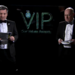 The presenters in suits ahead of a screen which reads VIP Awards