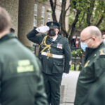 A member of the ceremonial unit salutes as staff observe a minute's silence
