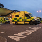Ambulances parked in a hospital bay at dusk