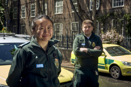 Joyce and Ben in LAS uniform smiling in front of a response car