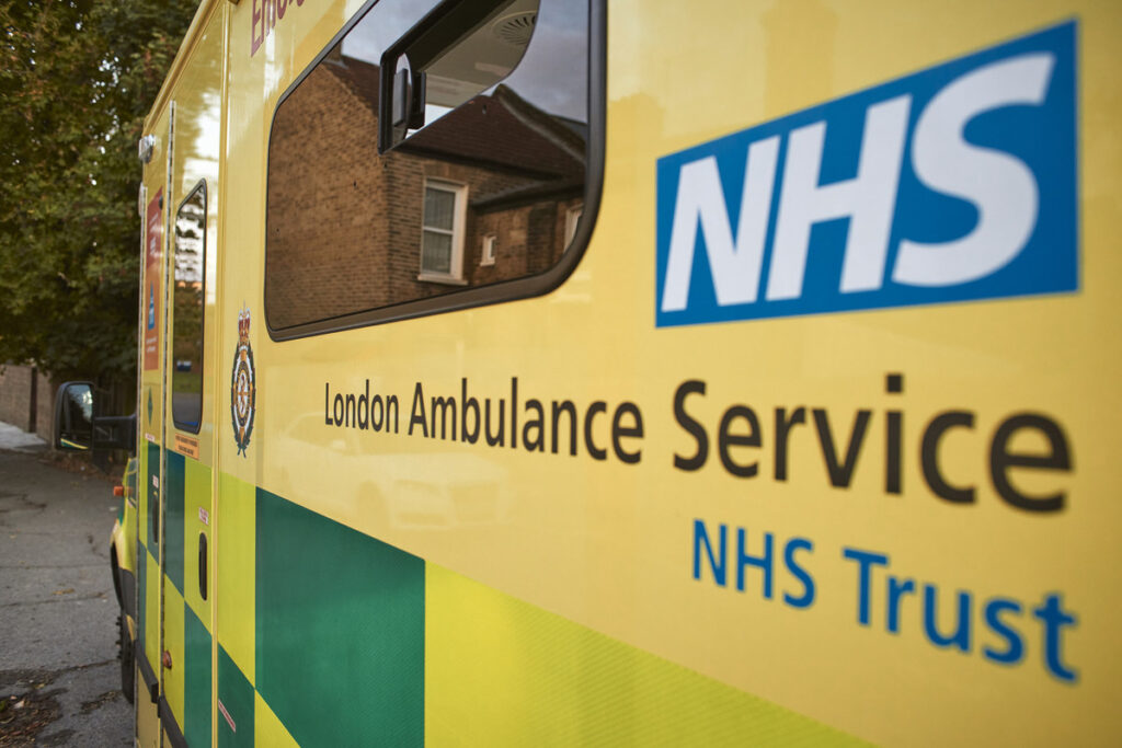 Stock image of the side of an ambulance with the NHS logo visible and the words London Ambulance Service NHS Trust