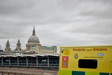 St Paul's Cathedral and City skyline in background and corner of an LAS ambulance in foreground