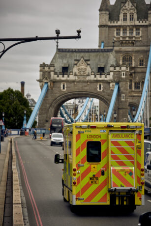 The rear of an ambulance shown driving over Tower Bridge