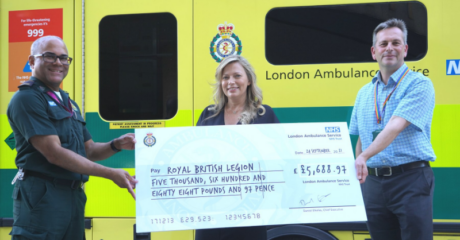 André holds a large novelty cheque with the amount raised with a represenative from the RBL alongside LAS Chief Executive Daniel Elkeles