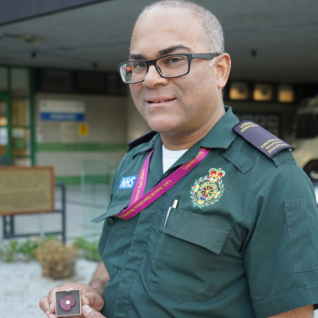 André in his Service uniform holding one of the poppy badges