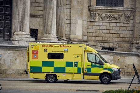 An ambulance shown parked in front of a historic London building