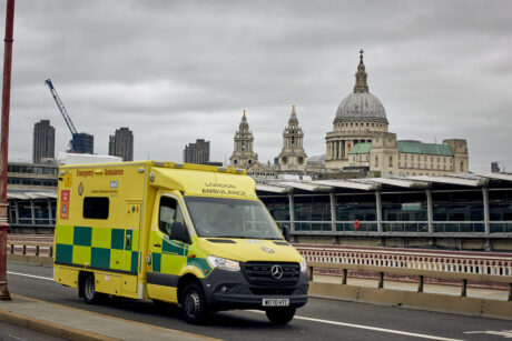An ambulance driving over Blackfriars Bridge with St Paul's Cathedral in background
