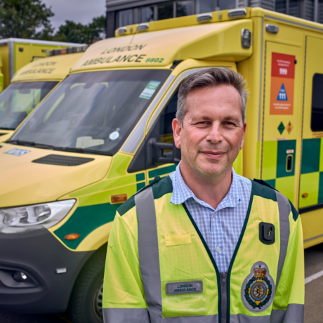 Daniel Elkeles photographed with a LAS tabard in front of an ambulance