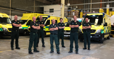 Stuart Law with colleagues from TRU and HART in a group in front of a range of ambulance vehicles