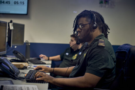 Two call handler at their work station with headsets taking 999 calls