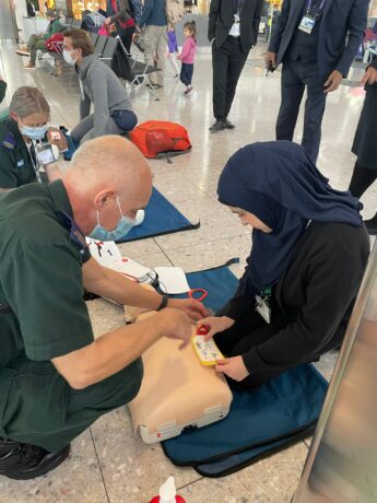 A medic showing a person how to put on defibrillator pads