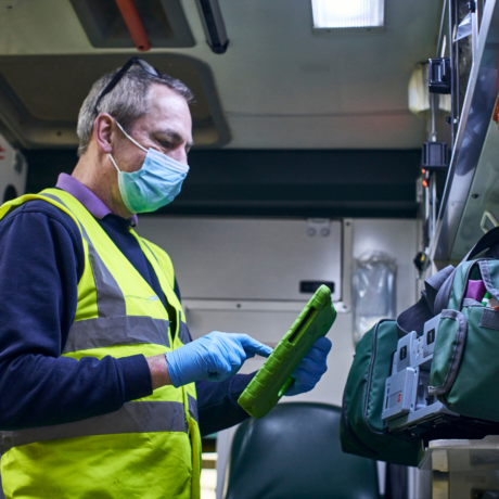 A Make Ready staff member in the back of an ambulance with a device monitoring the stock in the vehicle