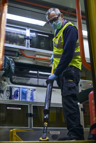 A Make Ready staff member cleaning the floor of inside an ambulance