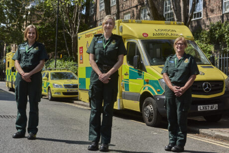 A group shot of the three members of the LAS end of life care team in uniform with an ambulance in the background
